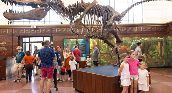 Children posing in front of a dinosaur statue at the Texas Science & Natural History Museum.